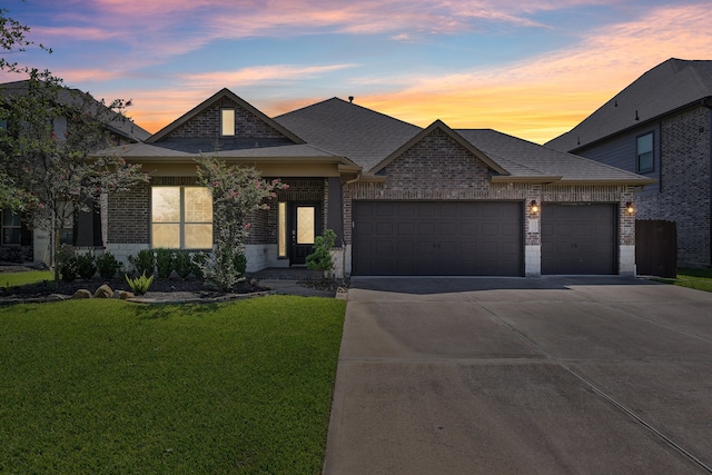 view of front of home with a garage and a lawn