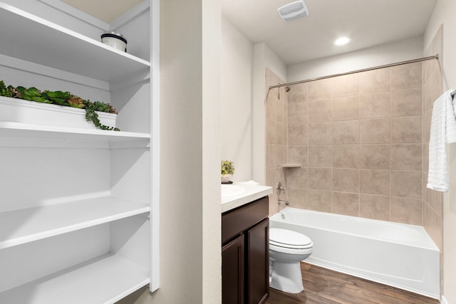 full bathroom featuring tiled shower / bath, hardwood / wood-style floors, vanity, and toilet