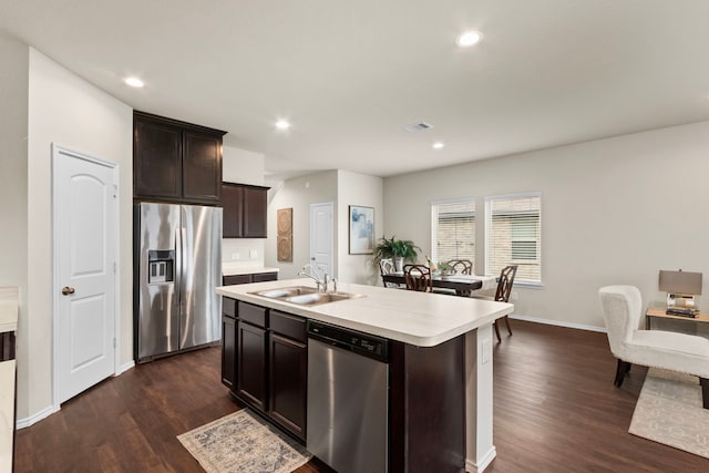 kitchen with a center island with sink, stainless steel appliances, dark hardwood / wood-style floors, sink, and dark brown cabinets