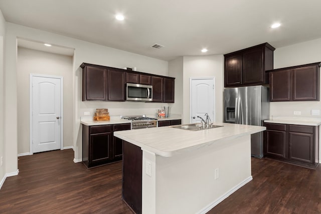 kitchen with an island with sink, dark wood-type flooring, appliances with stainless steel finishes, and sink