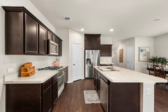 kitchen featuring a center island with sink, appliances with stainless steel finishes, dark hardwood / wood-style floors, sink, and dark brown cabinets