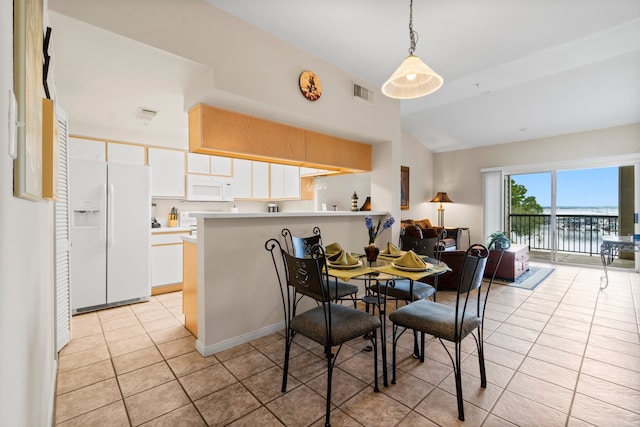 tiled dining room with vaulted ceiling