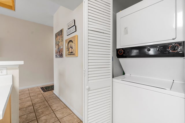 clothes washing area with light tile patterned floors and stacked washing maching and dryer