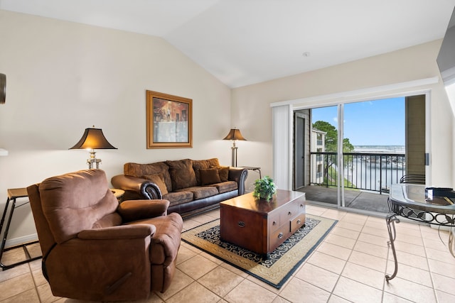 living room featuring lofted ceiling, light tile patterned floors, and a water view