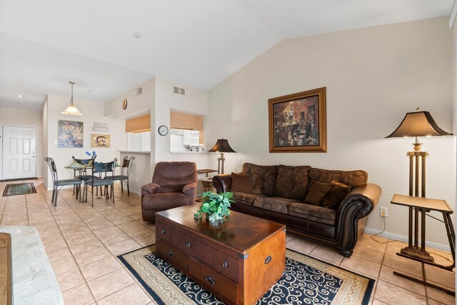 living room with vaulted ceiling and light tile patterned floors