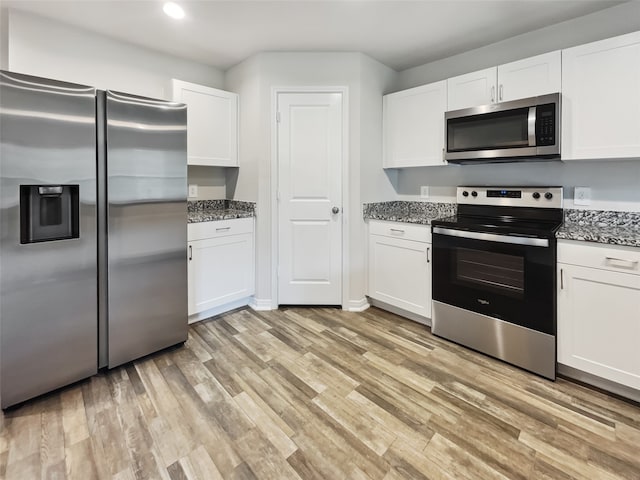 kitchen featuring stainless steel appliances, light wood-type flooring, and white cabinets