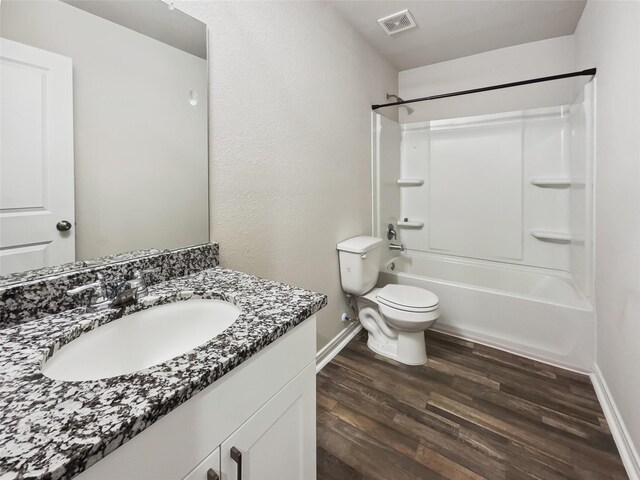 full bathroom featuring washtub / shower combination, toilet, hardwood / wood-style flooring, and vanity