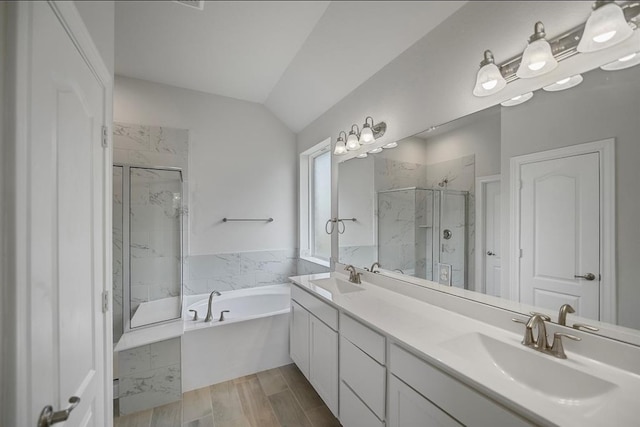 bathroom featuring vaulted ceiling, hardwood / wood-style flooring, vanity, and shower with separate bathtub