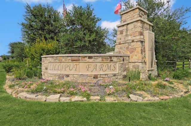 community / neighborhood sign with a yard