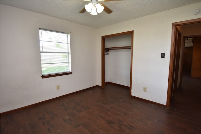 unfurnished bedroom with ceiling fan, a textured ceiling, a closet, and dark hardwood / wood-style flooring