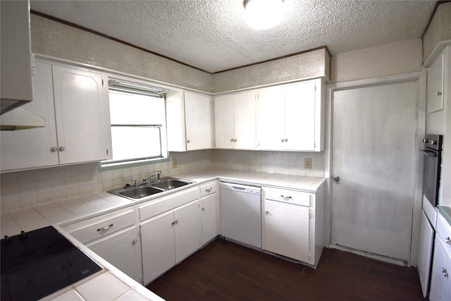 kitchen with black appliances, tile counters, sink, and white cabinetry