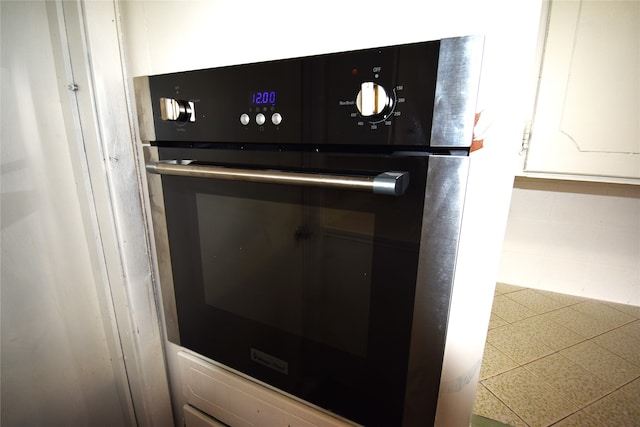 details with white cabinets and black oven