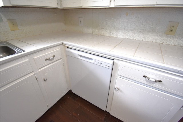 kitchen with white cabinetry, dark hardwood / wood-style floors, white dishwasher, and tile countertops