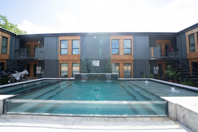 view of swimming pool with pool water feature