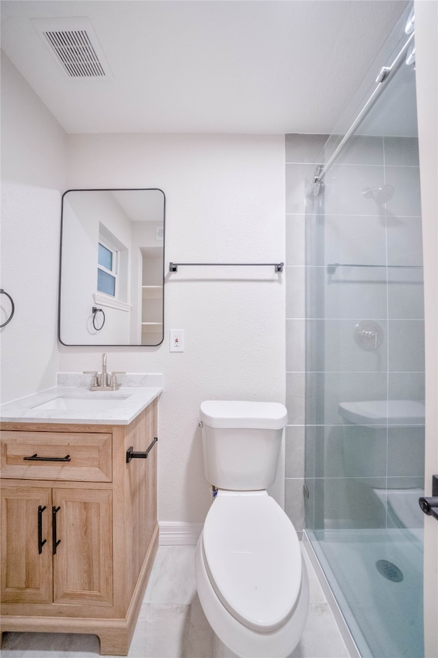 bathroom featuring a shower with shower door, tile patterned flooring, toilet, and vanity