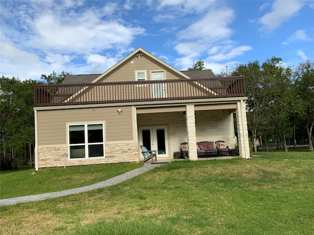 back of house with a yard, a patio area, a balcony, and french doors