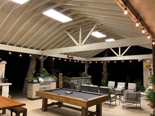 patio at night with an outdoor kitchen and a grill