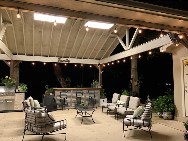 patio at night with grilling area and exterior bar