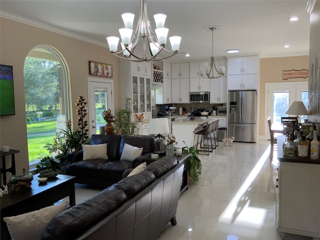 living room featuring ornamental molding, a wealth of natural light, and a chandelier