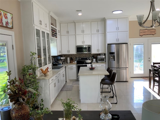 kitchen with appliances with stainless steel finishes, a kitchen island, and white cabinetry