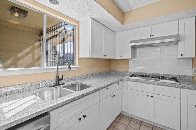 kitchen featuring white cabinetry, gas stovetop, dishwasher, sink, and light tile patterned flooring