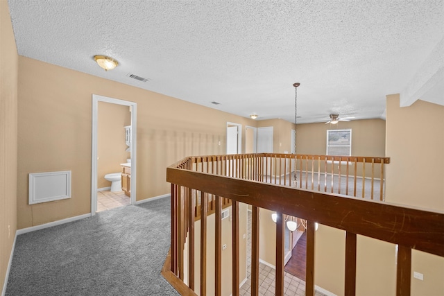 hall with a textured ceiling and carpet