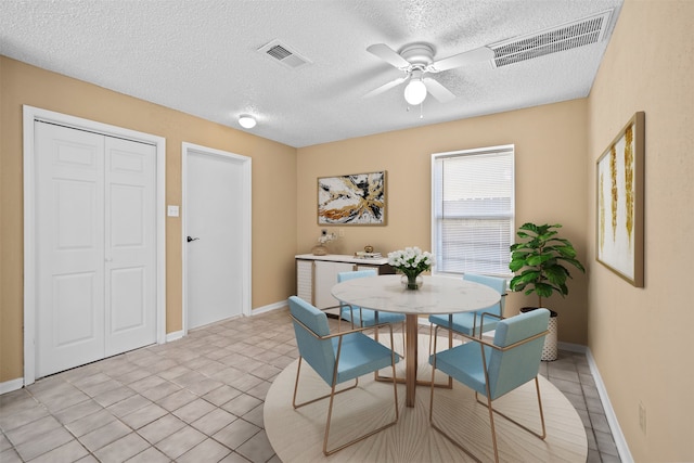 tiled dining area featuring a textured ceiling and ceiling fan