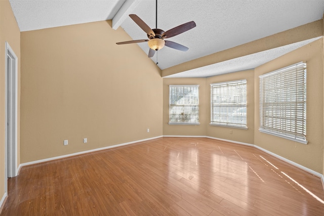 unfurnished room featuring ceiling fan, light hardwood / wood-style floors, vaulted ceiling with beams, and a textured ceiling