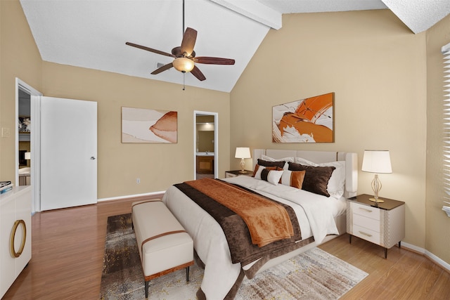 bedroom with lofted ceiling with beams, light hardwood / wood-style flooring, ensuite bathroom, and ceiling fan