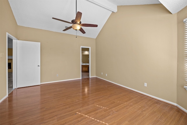 spare room featuring ceiling fan, wood-type flooring, and lofted ceiling with beams