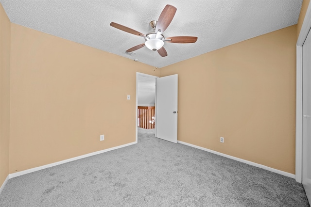 unfurnished bedroom with a textured ceiling, light colored carpet, and ceiling fan