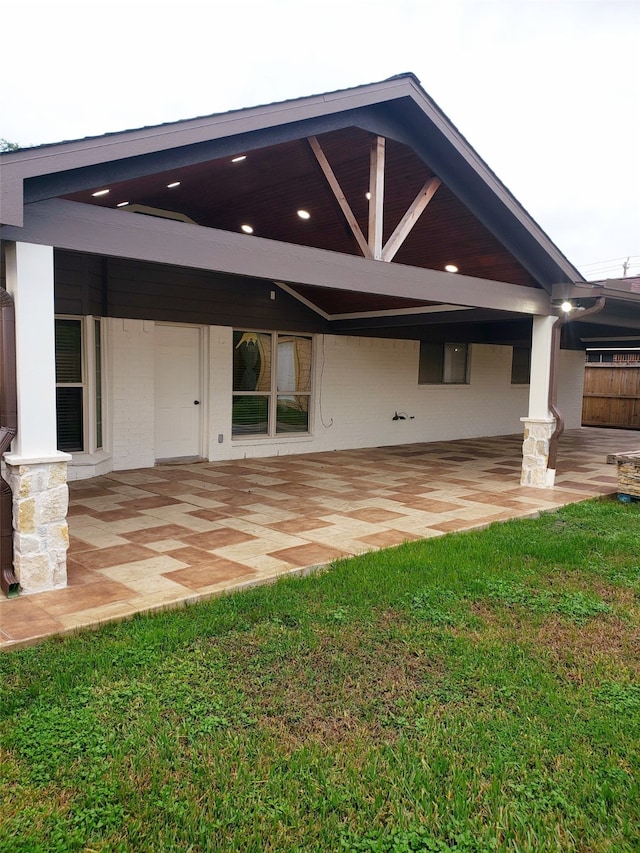 back of house with a patio area and a lawn