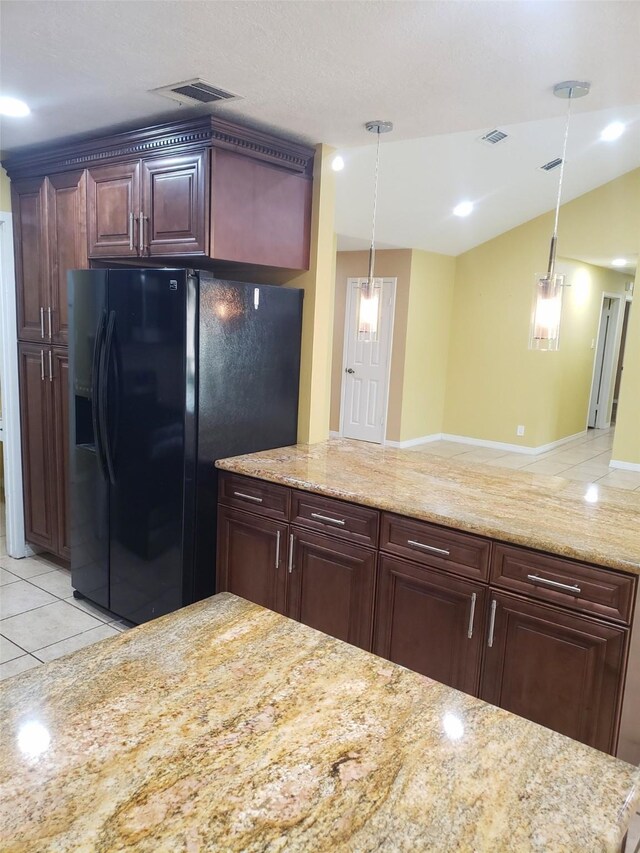 kitchen with light tile patterned floors, black fridge with ice dispenser, and decorative light fixtures