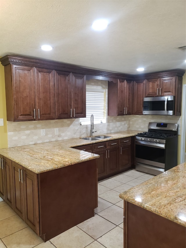 kitchen featuring light stone counters, sink, light tile patterned floors, and appliances with stainless steel finishes