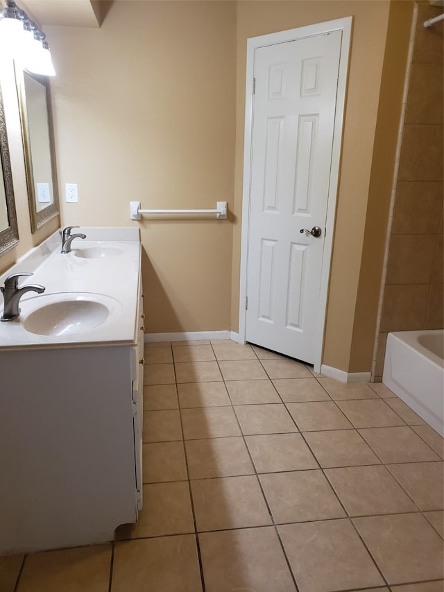 bathroom featuring a tub to relax in, vanity, and tile patterned floors