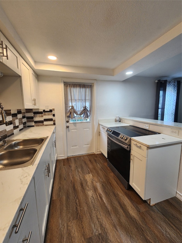 kitchen with electric stove, white cabinetry, a textured ceiling, dark hardwood / wood-style flooring, and decorative backsplash