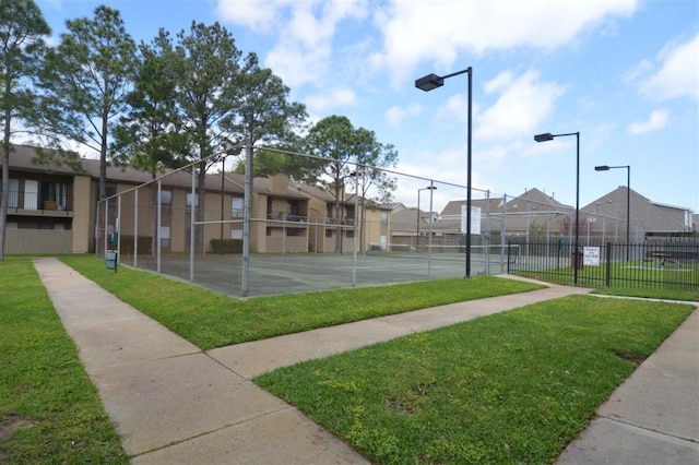 view of sport court featuring a lawn