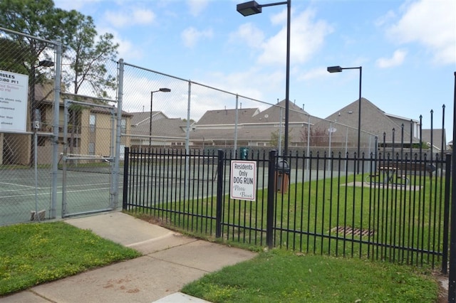 view of tennis court with a yard