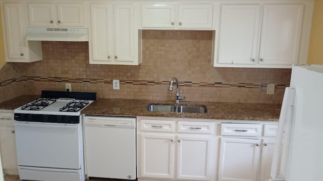 kitchen with dark stone countertops, white appliances, sink, and white cabinets