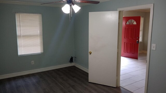 spare room featuring dark wood-type flooring, ceiling fan, and ornamental molding