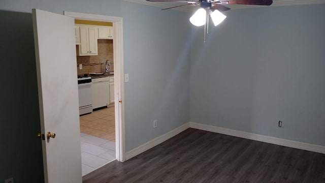 unfurnished room featuring ceiling fan, dark hardwood / wood-style floors, and sink