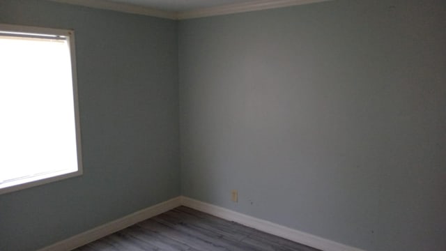 empty room with crown molding and hardwood / wood-style flooring