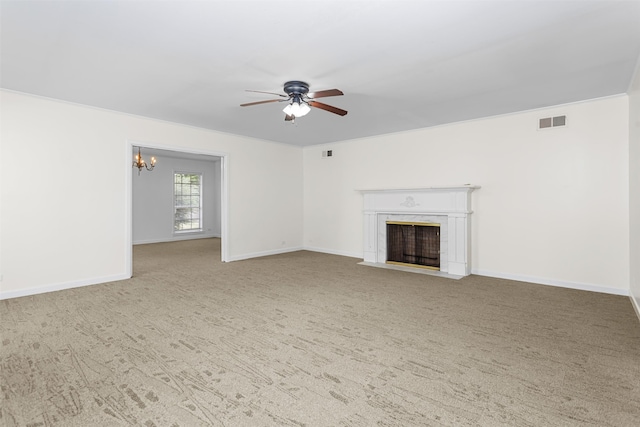 unfurnished living room featuring a premium fireplace, ceiling fan with notable chandelier, and light carpet