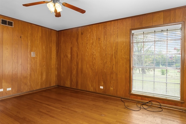 spare room with hardwood / wood-style flooring, ceiling fan, and a healthy amount of sunlight