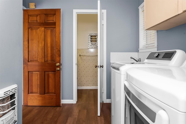 laundry area featuring washer and clothes dryer, dark hardwood / wood-style flooring, and cabinets