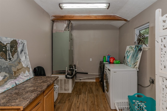 clothes washing area featuring a textured ceiling, washing machine and dryer, and hardwood / wood-style flooring