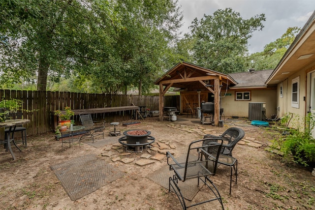 view of patio / terrace featuring cooling unit, a gazebo, and an outdoor fire pit