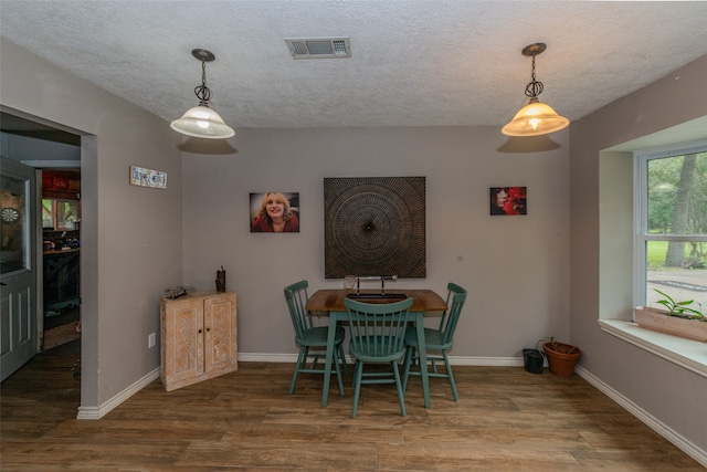 dining room with hardwood / wood-style flooring and a textured ceiling