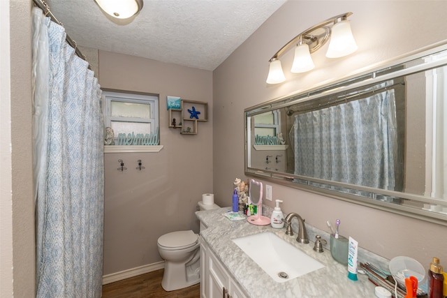 bathroom featuring vanity, toilet, hardwood / wood-style floors, and a textured ceiling