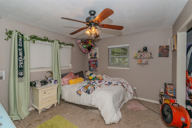 bedroom featuring ceiling fan, light colored carpet, and a textured ceiling